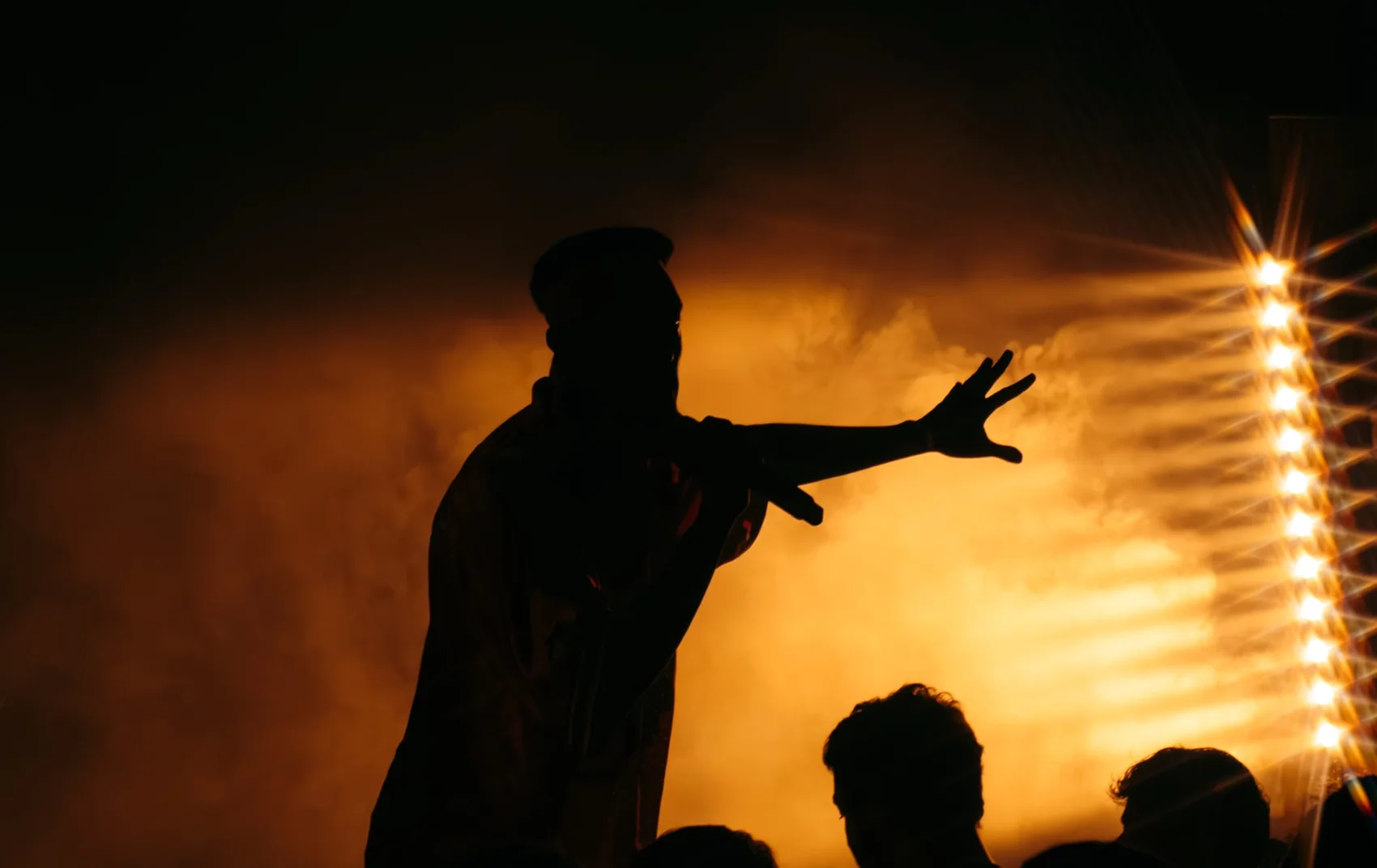Avraham Lagasa in silhouette against amber stage lights