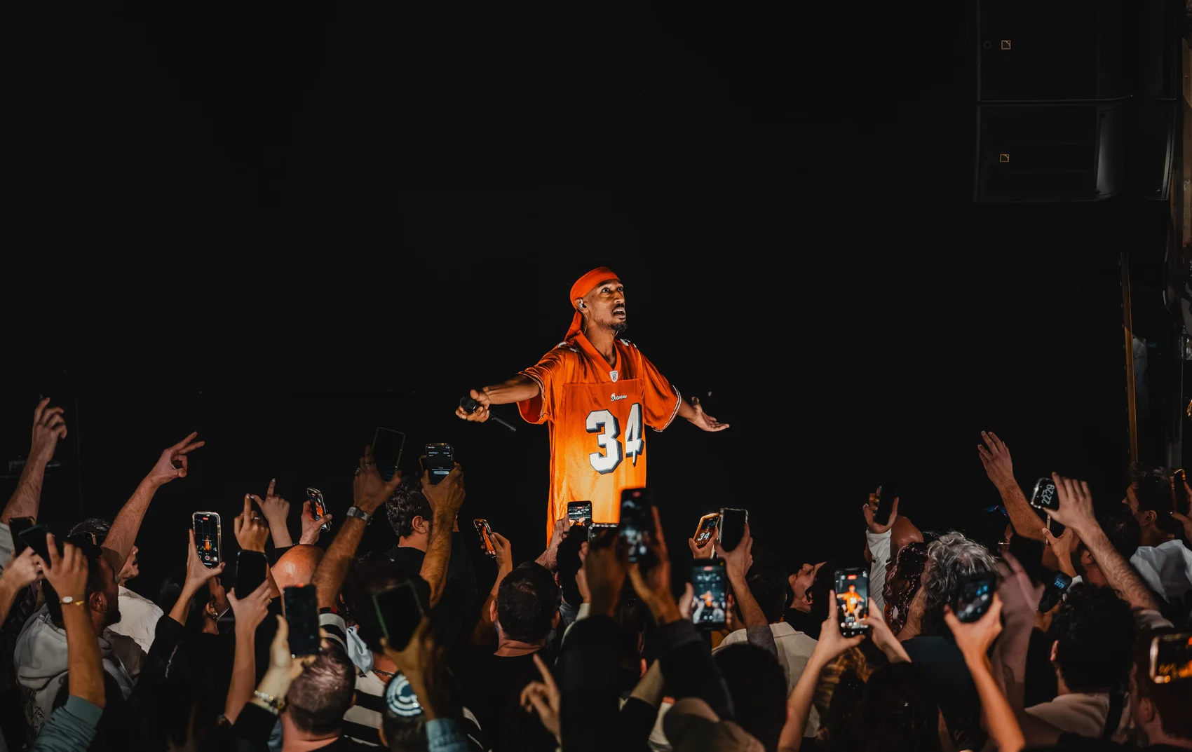 Avraham Lagasa performing among raised hands in the crowd