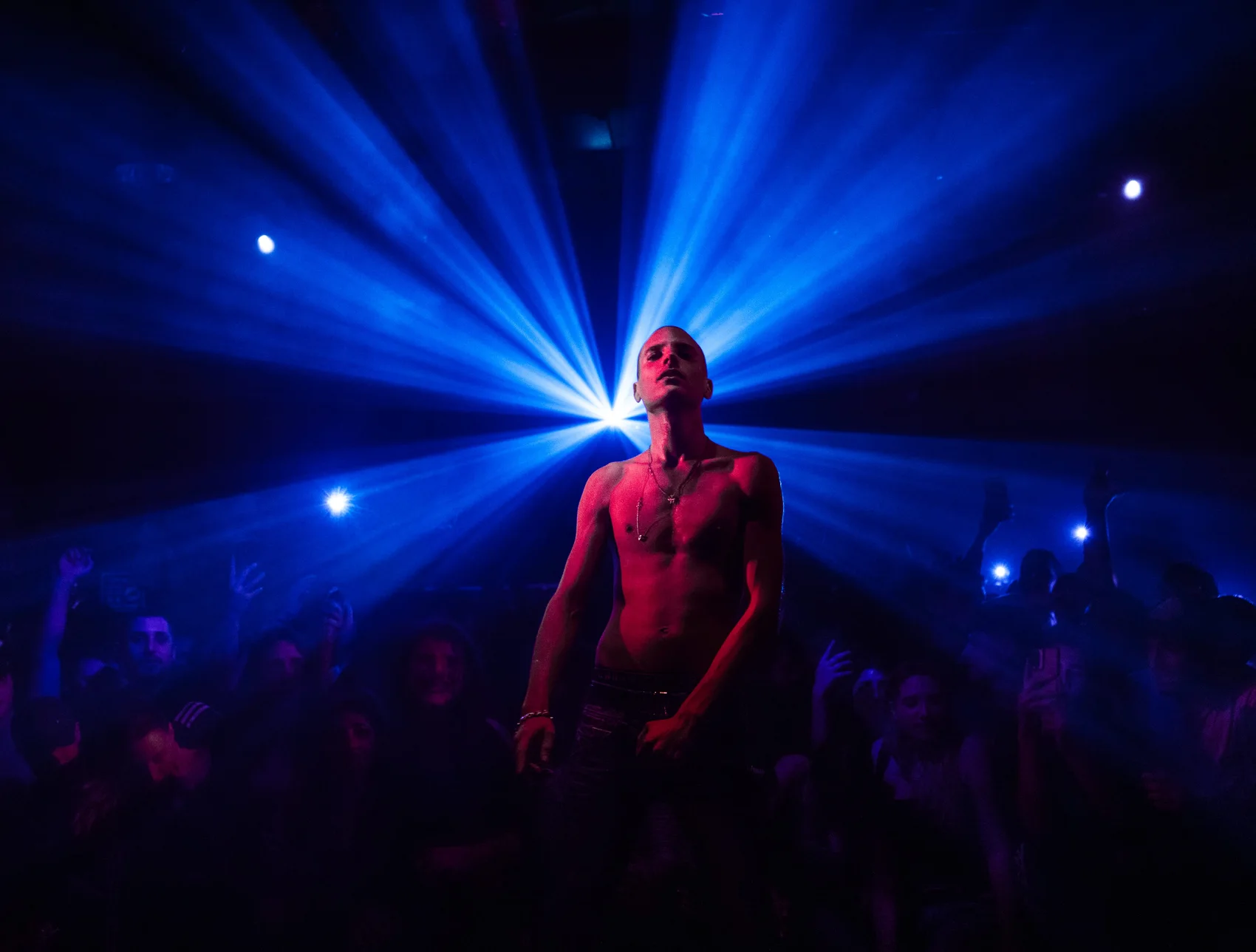Dudu Faruk performing in front of radial blue stage light