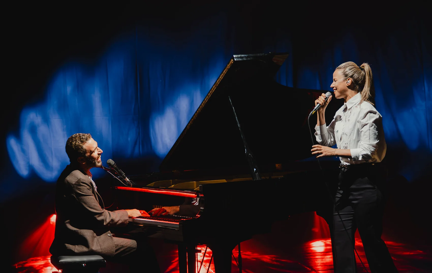 Shlomi Shaban at the piano with a singer on stage