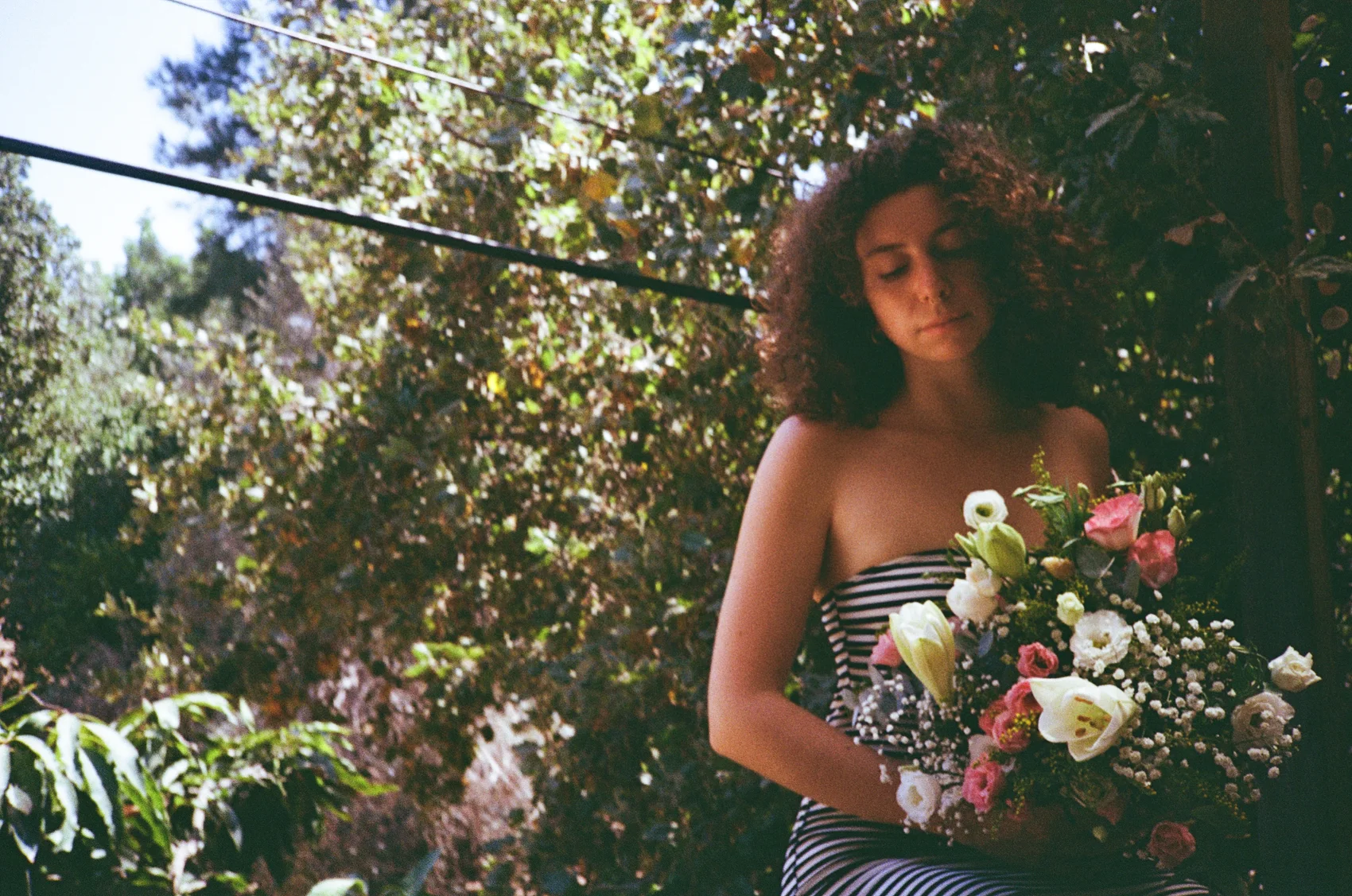 Natural-light portrait on 35mm film among green foliage